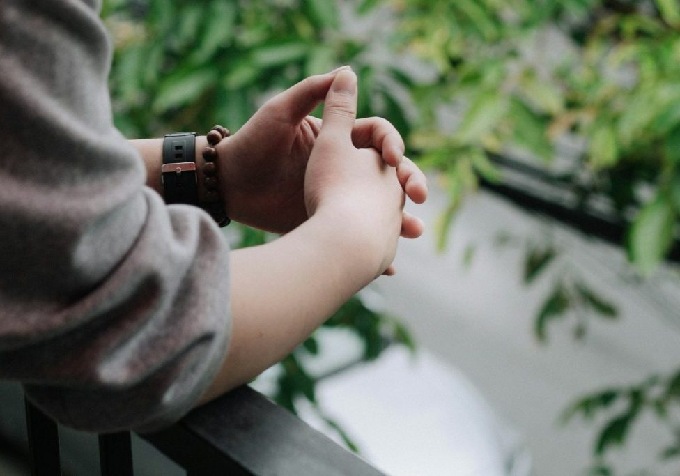 person in gray long sleeve shirt holding babys hand